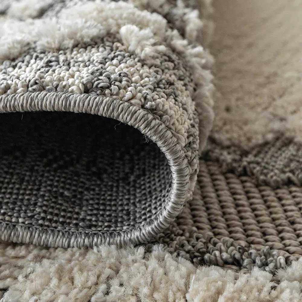 Detailed close-up of the Mist Haven Rug showcasing its tightly stitched edges and soft, plush gray and cream weave.