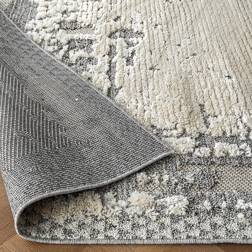 Detailed view of the Mist Haven Rug showcasing its durable backing and plush gray and cream textured surface.