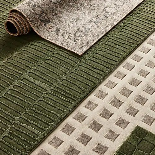 A close-up view of green and beige modern rugs with textured patterns, showcasing RugVision’s attention to detail and innovative designs.